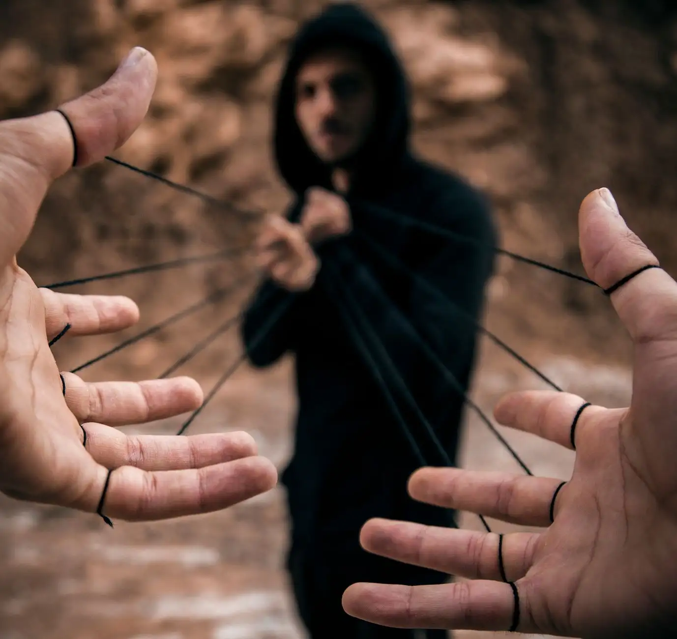 Conceptual image of a man controlling hands with strings, reflecting manipulation.